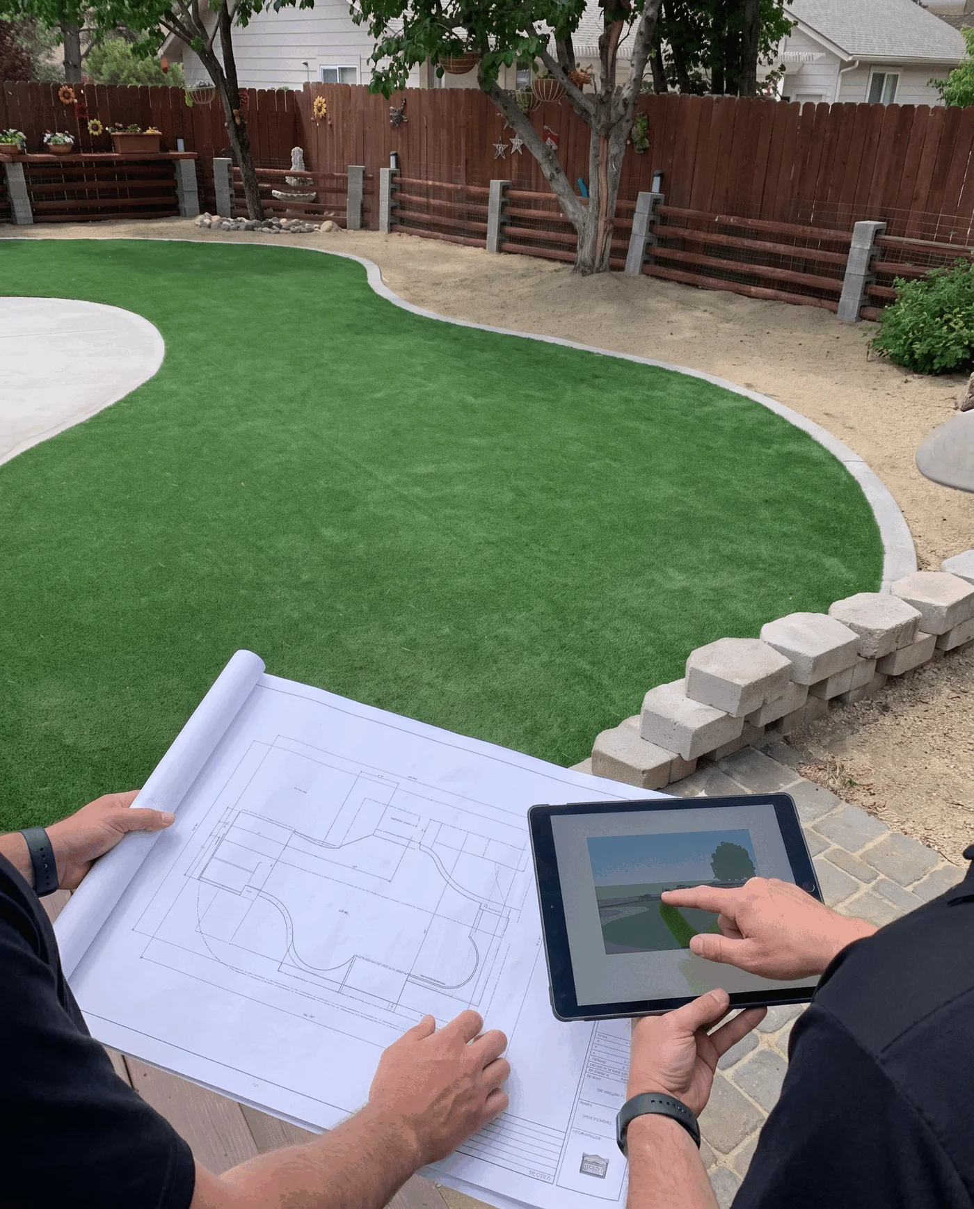 Client and designer reviewing an artificial-turf outdoor-living direction together