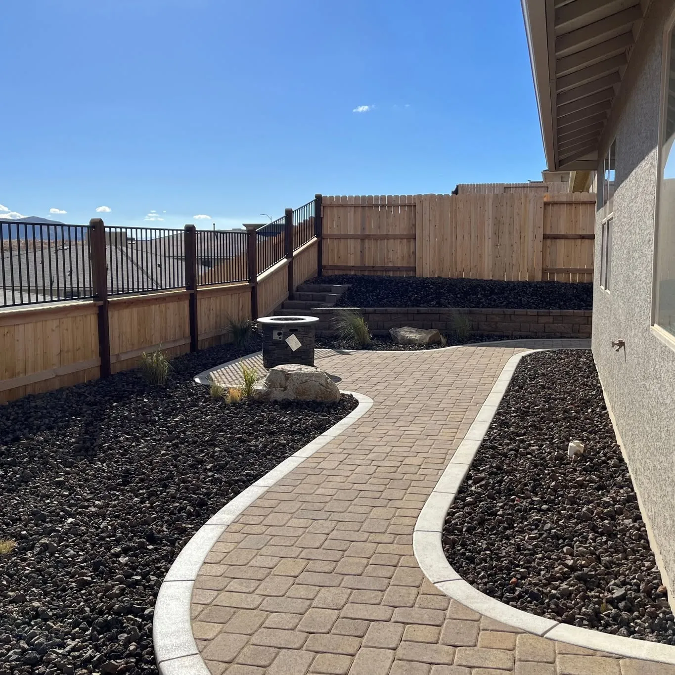 Completed paver surface within a landscaped yard