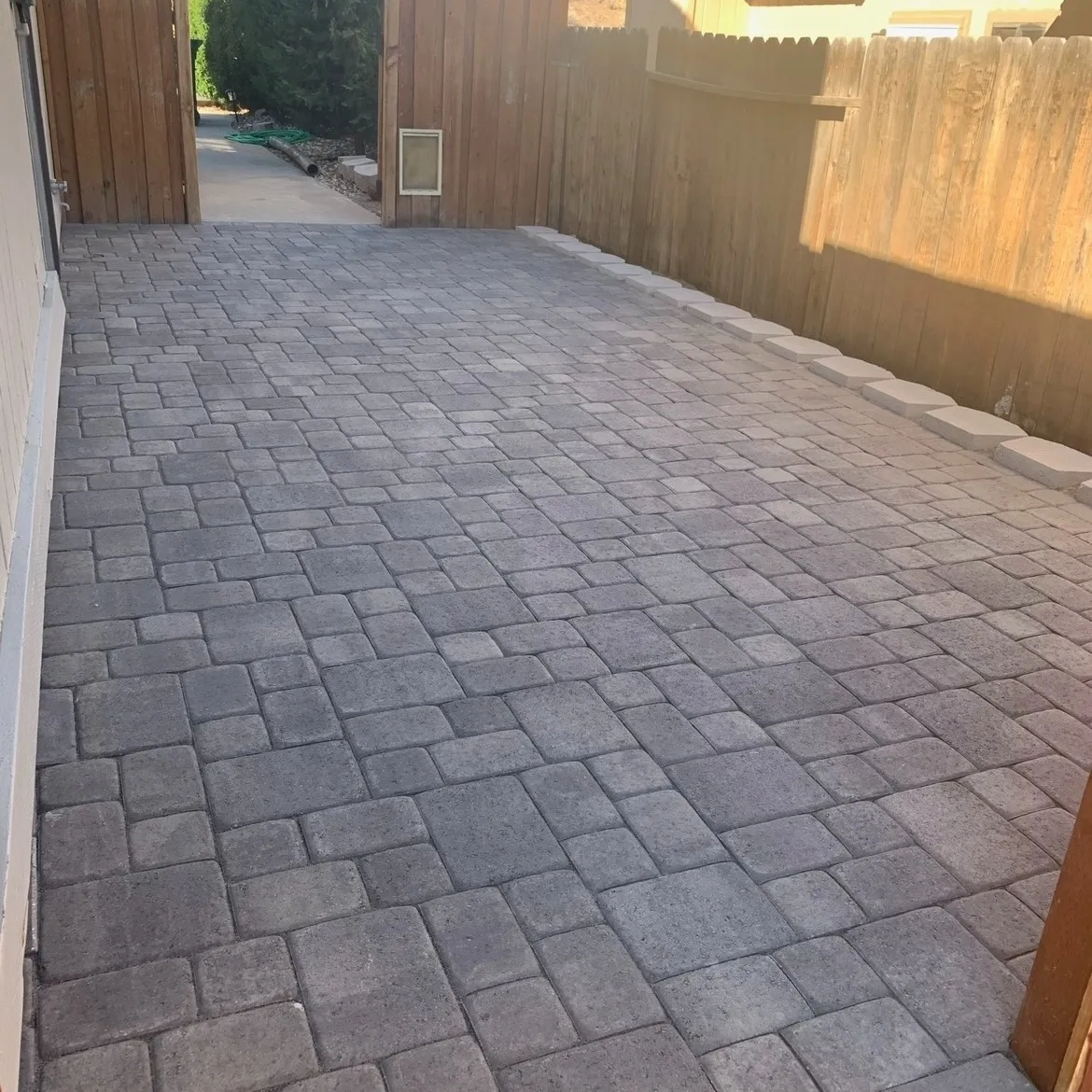 Completed patterned paver surface and landscaped edge